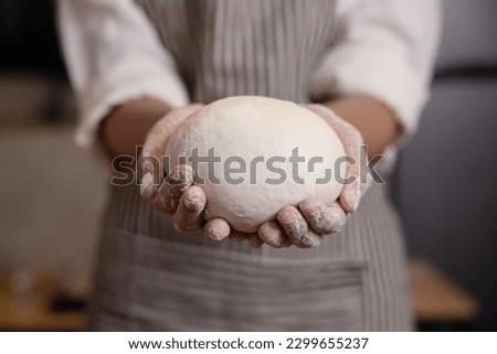Woman Hands Hold the Dough Before Putting the Dough into the Oven
