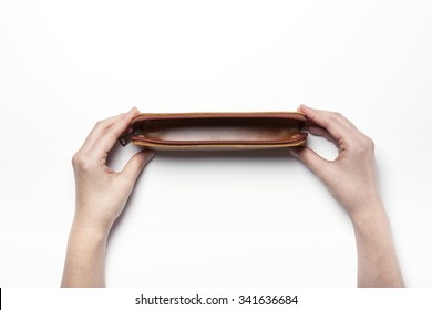 A Woman Hands Hold A Empty(blank, Hollow, Vacant) Brown Leather Pencil Case On The White Desk(table) Top View Isolated White At The Studio.