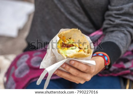 Woman hands hold mexican gordita, filled tortilla 