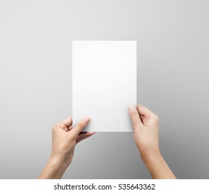 Woman Hands Holding Blank Paper Sheet A5 Size Or Letter Paper On Grey Background.