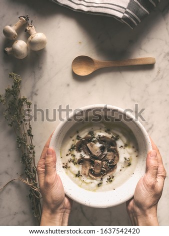 woman hands holding a bowl of mushroom soup. Autumn warm puree.  Cozy warm food. Healthy vegetarian dinner