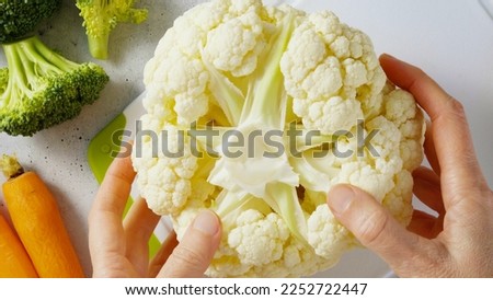 Woman hands holding cauliflower. Close-up view from above, recipe, cooking, preparation process concept