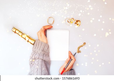 Woman hands holding clear white notebook, golden sparkles, new year, flat lay. - Shutterstock ID 1576861693