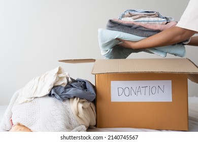 Woman hands holding clothes putting in a donation box. Sharing, Help, Donation concept - Powered by Shutterstock