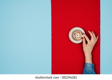 Woman Hands Holding Coffee Mug Or Cup On Colorful Table. Photograph Taken From Above, Top View With Copy Space