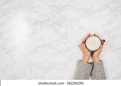 Woman Hands Holding Coffee Mug Or Cup On Colorful Table. Photograph Taken From Above, Top View With Copy Space