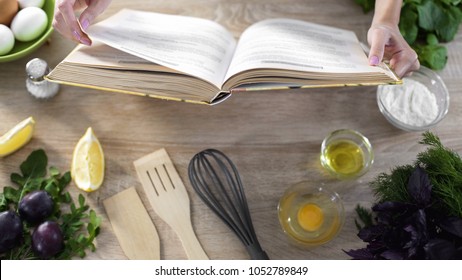 Woman hands holding cooking book table, girl choosing recipe for family dinner - Shutterstock ID 1052789849