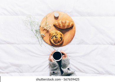 Woman Hands Holding Cup Of Coffee In Bed. Top View Of Breakfast In Bed