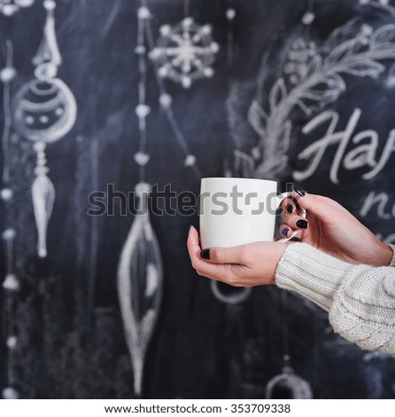 Woman hands holding cup on Happy New Year background