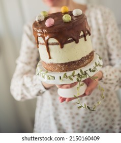 Woman Hands Holding Easter Naked Sponge Cake With Whipped Cream And Caramel Sauce.