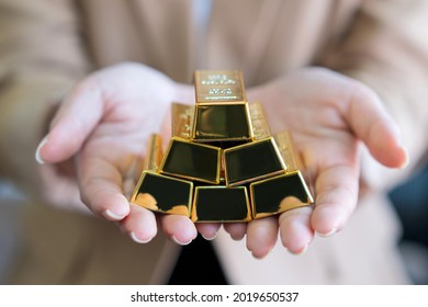 woman hands holding gold bars stack as secure investment. - Shutterstock ID 2019650537