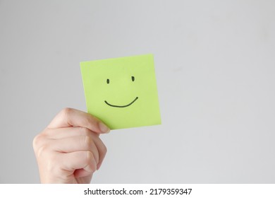 Woman hands holding green smile face paper,  good feedback rating,think positive, customer review, assessment, world mental health day, Compliment Day. - Shutterstock ID 2179359347