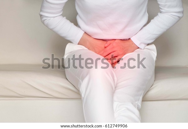  woman with hands holding her crotch in\
pain.\
Bladder pain.