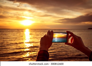 woman hands holding mobile phone at sunset - Powered by Shutterstock