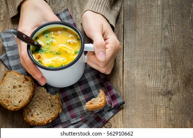 Woman Hands Holding Mug Of Vegetable Soup With Parsley And Croutons Over Wooden Background - Healthy Winter Vegetarian Food