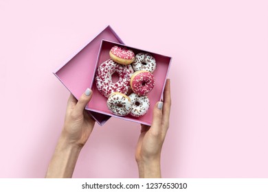 Woman hands holding  open box with donuts on pink background. Flat lay style. Copy space. - Powered by Shutterstock