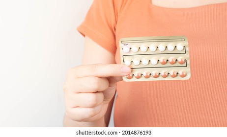 Woman hands holding oral contraceptive pills blister. Hormones used to prevent pregnancy and treat other medical conditions, such as PCOS, endometriosis, amenorrhea or acne. Gynecology concept.