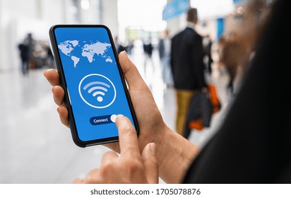 Woman hands holding phone with app vpn creation Internet protocols for protection private network on screen in a pedestrian zone.
