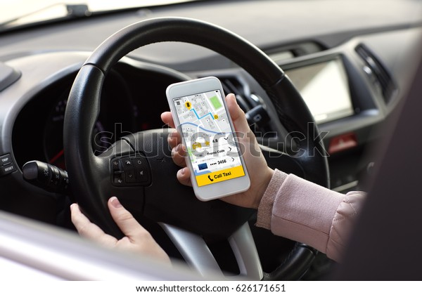 woman\
hands holding phone with app call taxi in the\
car