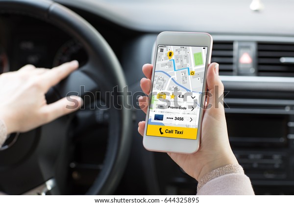 woman\
hands holding phone with app call taxi in the\
car