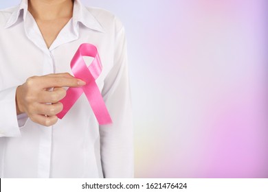 Woman hands Holding Pink Cancer Awareness Ribbon on pink bokeh background. - Shutterstock ID 1621476424