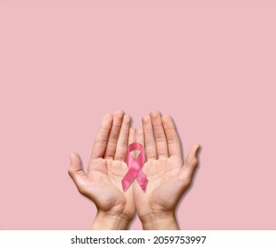 Woman hands holding pink ribbon, breast cancer awareness, October pink concept - Shutterstock ID 2059753997