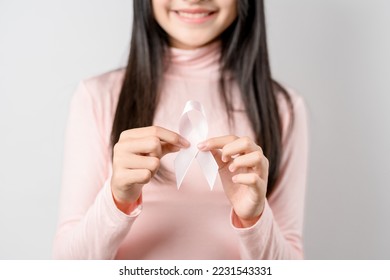 woman hands holding pink ribbon, Breast cancer awareness, world cancer day, national cancer survivor day in february concept.	 - Shutterstock ID 2231543331
