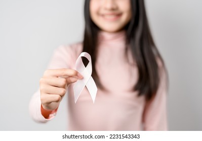 woman hands holding pink ribbon, Breast cancer awareness, world cancer day, national cancer survivor day in february concept.	 - Shutterstock ID 2231543343