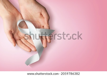 Woman hands holding pink ribbon, breast cancer awareness, October pink concept