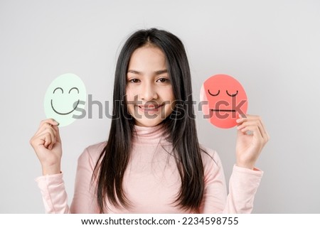 Woman Hands holding sad face hiding or behind happy smiley face, bipolar and depression, mental health concept, personality, mood change, therapy healing split concept.