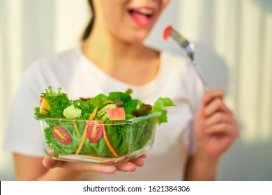 Woman Hands Holding Salad Bowl With Eating Tomato And Various Green Leafy Vegetables On The Table At The Home.