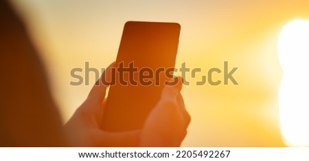 Woman hands holding smartphone at outdorrs in the evening