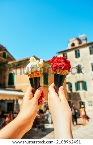 Woman hands holding vanilla gelato ice cream and with berries.