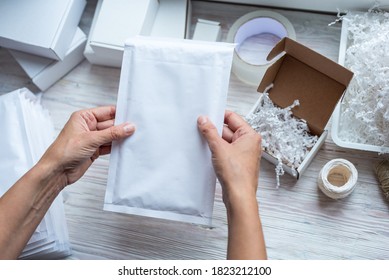 Woman Hands Holding White Paper Bubble Envelope For Postal Shipp