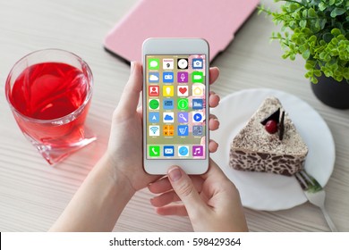 Woman Hands Holding White Phone With Home Screen Icons Apps In Cafe