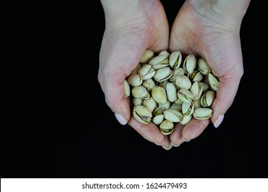 Woman hands holding a wooden bowl with mixed nuts. Healthy food and snack. Walnut, pistachios, almonds, hazelnuts and cashews