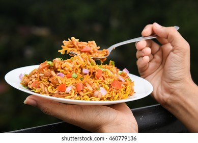 Woman Hands Holding/serving Spicy Bhel Puri. Chat Item, Indian Fast/street Food North India Mumbai. Savory Snack With Chopped Tomatoes, Green Chillies, Coriander Leaf Served With Sweet/green Chutney