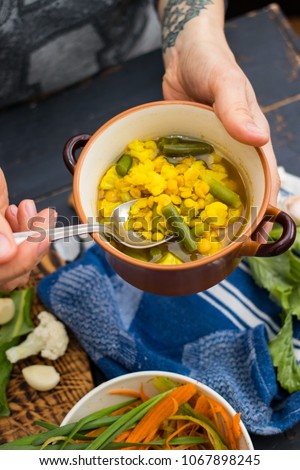 Woman hands holds hot Indian lentil peas soup with cauliflower. Dinner or lunch In bowl on napkin. Organic natural ingredients. Raw vegan vegetarian healthy food