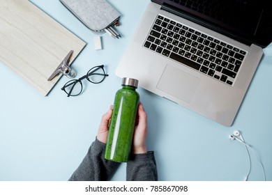 Woman hands with Laptop and green smoothies with apple on blue table. Top view, flat lay - Powered by Shutterstock