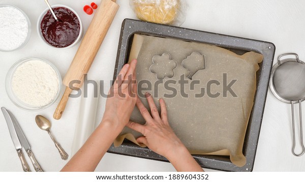 Woman hands line\
baking pan with parchment paper. Shortbread cookie recipe. Step by\
step baking process