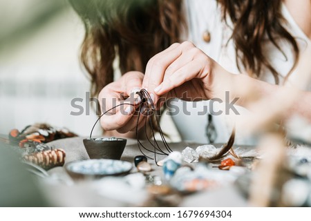 Woman hands making handmade gemstone jewellery, home workshop. Women artisan creates jewellery. Art, hobby, handcraft concept