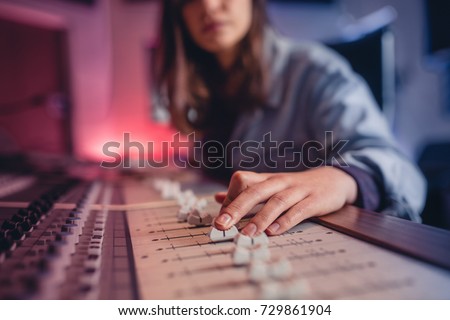 Woman hands mixing audio in recording studio. Female hands working on music mixer. Music production technology.