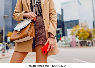 Woman hands with mobile phone. Stylish girl in beige coat chatting. Modern city background.  - Shutterstock ID 1291933264