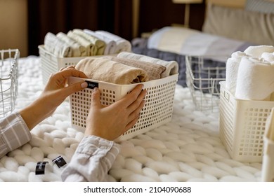 Woman Hands Neatly Folded Linens And Towels Use Marie Kondo Method With Sticky Label Tags Top View Closeup. Female Housewife Arms Sticking Names On Case Box For Comfortable Storage In Bedroom Closet