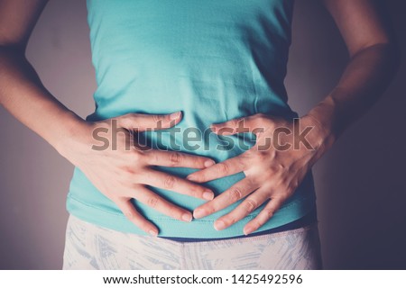 woman hands on her stomach, probiotics and prebiotics food for gut health, having stomachache, leaky gut, woman health
