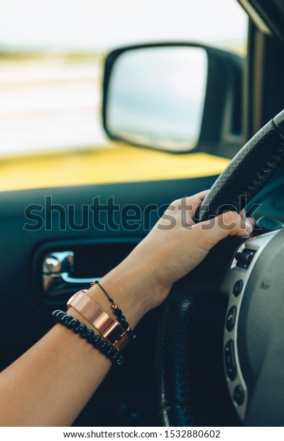woman hands on steering\
wheel close up