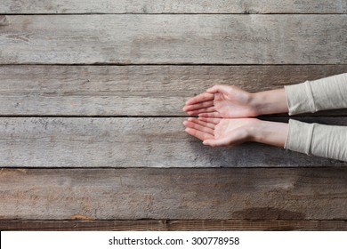 woman hands with open palms over wooden table