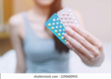 Woman hands opening birth control pills in hand. Eating Contraceptive Pill.	