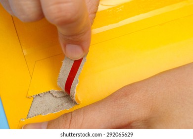 Woman Hands Opening Mail Package With Easy Open Strip.