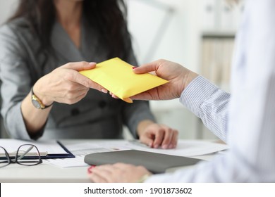 Woman hands over full envelope to her interlocutor. Salary in an envelope concept - Shutterstock ID 1901873602